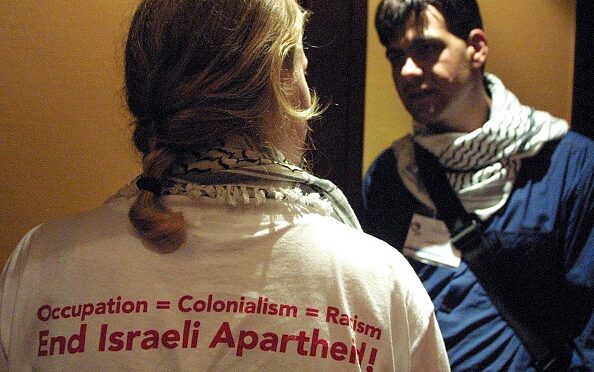 Members of the Palestinian delegation to the International Youth Summit in Durban discuss issues during a break in the proceedings, 27 August 2001. One wears a tshirt that reads Occupation = Colonialism = Racism. End Israeli Apartheid. AFP PHOTO/ANNA ZIEMINSK